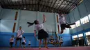 Seorang siswi menangkis serangan anak laki-laki yang menggunakan pedang selama berlatih Krabi Krabong di sekolah Thonburee Woratapeepalarak, Thonburi, Bangkok (8/7/2019). Krabi Krabong merupakan seni bela diri Thailand yang dipersenjatai pisau dan perisai kayu. (AFP Photo/Lillian Suwanrumpha)