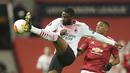 Bek AC Milan, Fikayo Tomori menendang bola dari kawalan striker Manchester United, Anthony Martial pada leg pertama babak 16 besar Liga Europa di Old Trafford, Inggris, Jumat (12/3/2021). Milan berhasil mencuri satu gol tandang yang akan jadi modal berharga untuk leg kedua. (AP Photo/Dave Thompson)