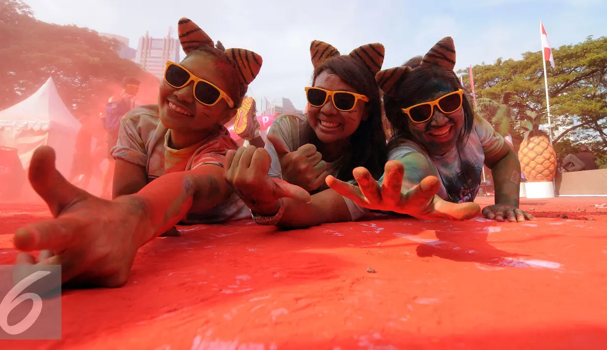 Peserta lari santai 5K Colour Run 2016 bergaya usai mengikuti lomba di Parkir Timur Senayan, Jakarta, Minggu (7/8). Event ini perpaduan antara olahraga dan entertainment. (Liputan6.com/Helmi Fithriansyah)