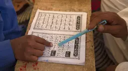 Seorang anak belajar Al-Quran selama bulan suci Ramadan di Jammu Kashmir Al Fallah Yateem Trust, Srinagar, India, Kamis (7/5/2020). Para ulama dan otoritas agama setempat mendesak warga untuk beribadah di rumah untuk mencegah penyebaran virus corona COVID-19. (AP Photo/Dar Yasin)