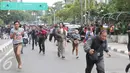 Seorang jurnalis (kanan) bersama sejumlah warga berlarian usai mendengar isu bom yang akan kembali meledak pasca ledakan yang terjadi di Pos polisi dekat pusat perbelanjaan Sarinah, Jalan Thamrin, Jakarta, Kamis (14/1). (Liputan6.com/Angga Yuniar)