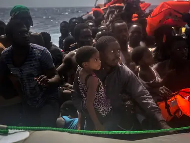 Sejumlah imigran menunggu di atas perahu karet untuk diselamatkan di lepas pantai Libya, Selasa (25/7). Kapal penyelamat kemanusiaan milik LSM asal Spanyol, Proactiva Open Arms, menemukan 13 jasad di atas perahu karet tersebut. (AP/Santi Palacios)