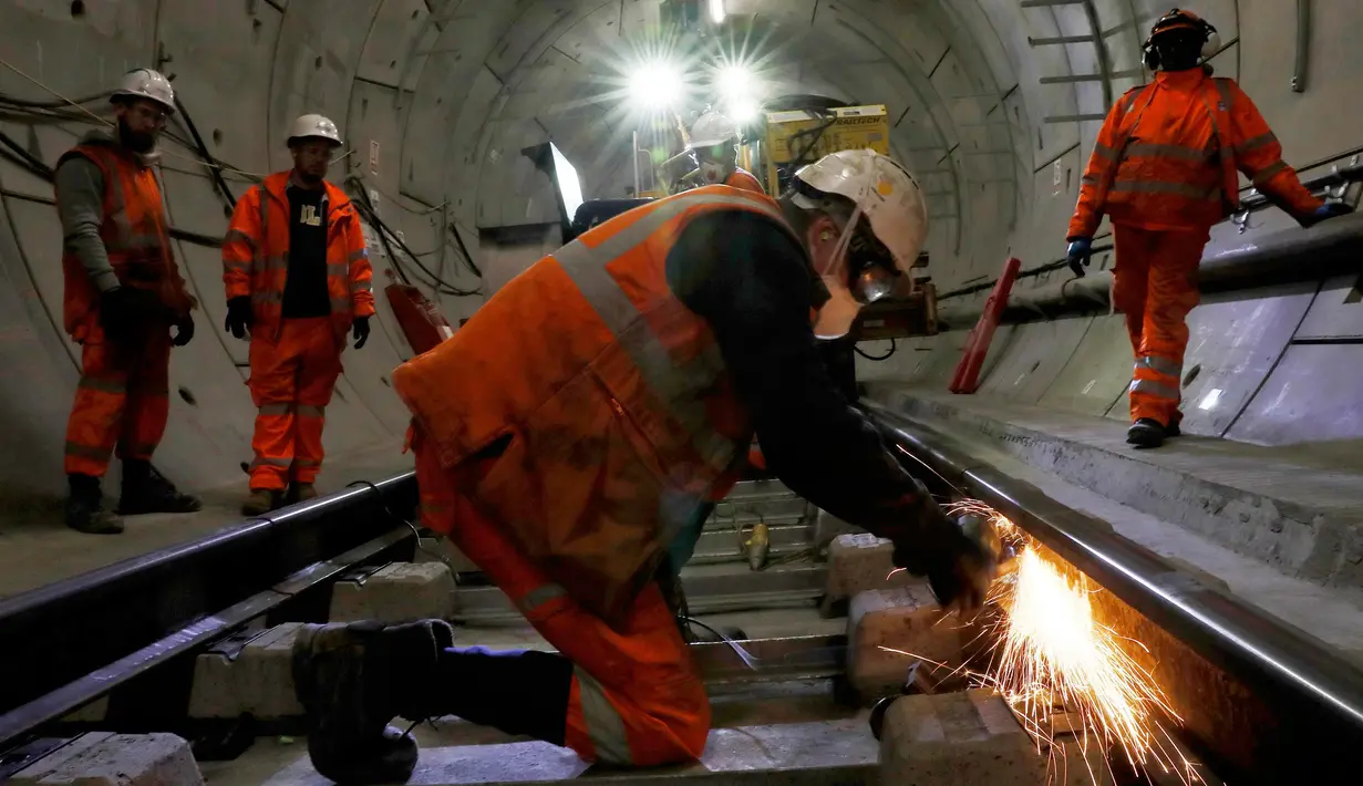 Seorang pekerja mengelas jalur kereta api saat menyelesaikan pembuatan proyek Crossrail di Stepney, London, Inggris, (16/11). Proyek ini memiliki panjang sekitar 180 kilometer. (REUTERS/Stefan Wermuth)