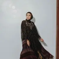 Dress hitam berbahan tile dengan motif bunga dan detail payet pada bagian dada sangat anggun untuk dikenakan pada acara buka bersama di hotel. (instagram/zaskiasungkar15)