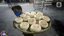 Pekerja membawa kue bulan di Industri Rumahan Kue Bulan Putri Lauw, Pondok Sentul, Ciater, Tangerang Selatan, Selasa (10/11/2020). Pada masa pandemi sekarang, produksi kue tradisional khas Tionghoa tersebut menurun sesuai pesanan pembeli. (merdeka.com/Dwi Narwoko)