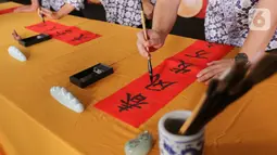 Guru menampilkan Chinese Calligraphy  dalam acara Sampoerna Academy Reinforces The IGNITE Values Through Lunar New Year di Sampoerna Academy BSD, Tangerang Selatan, Jumat (28/01/2022). Perayaan Imlek tahun ini mendorong para siswa untuk menerapkan nilai-nilai IGNITE.(Liputan6.com/Fery Pradolo)