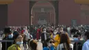 Pengunjung mengenakan masker untuk mencegah penyebaran virus corona keluar dari Kota Terlarang di Beijing, Rabu, (7/10/2020). Menurut kementerian budaya dan pariwisata China, libur Hari Nasional menghasilkan $ 45,9 miliar pendapatan pariwisata. (AP Photo/Andy Wong)