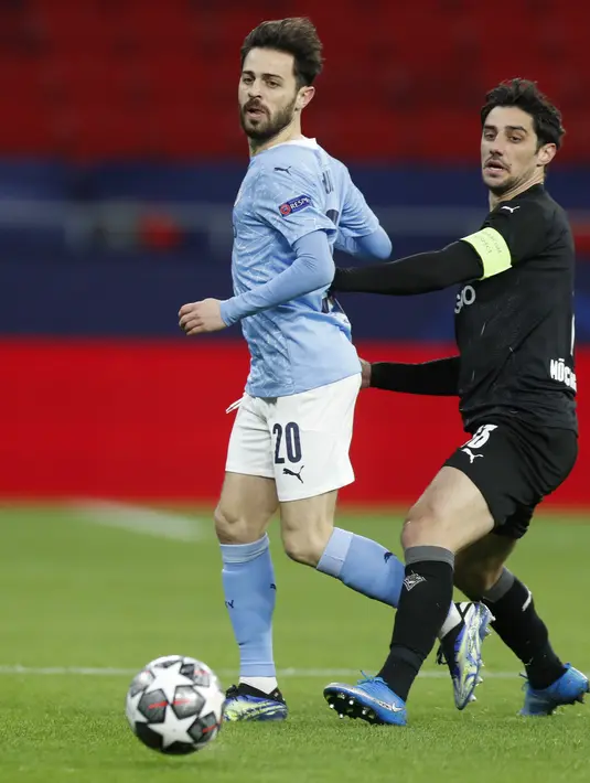 Gelandang Manchester City, Bernardo Silva berebut bola dengan gelandang Borussia Monchengladbach, Lars Stindl pada leg kedua babak 16 besar Liga Champions di Puskas Arena, Rabu (17/3/2021) dini hari WIB. Manchester City menang 2-0 atas Borussia Moenchengladbach. (AP Photo/Laszlo Balogh)