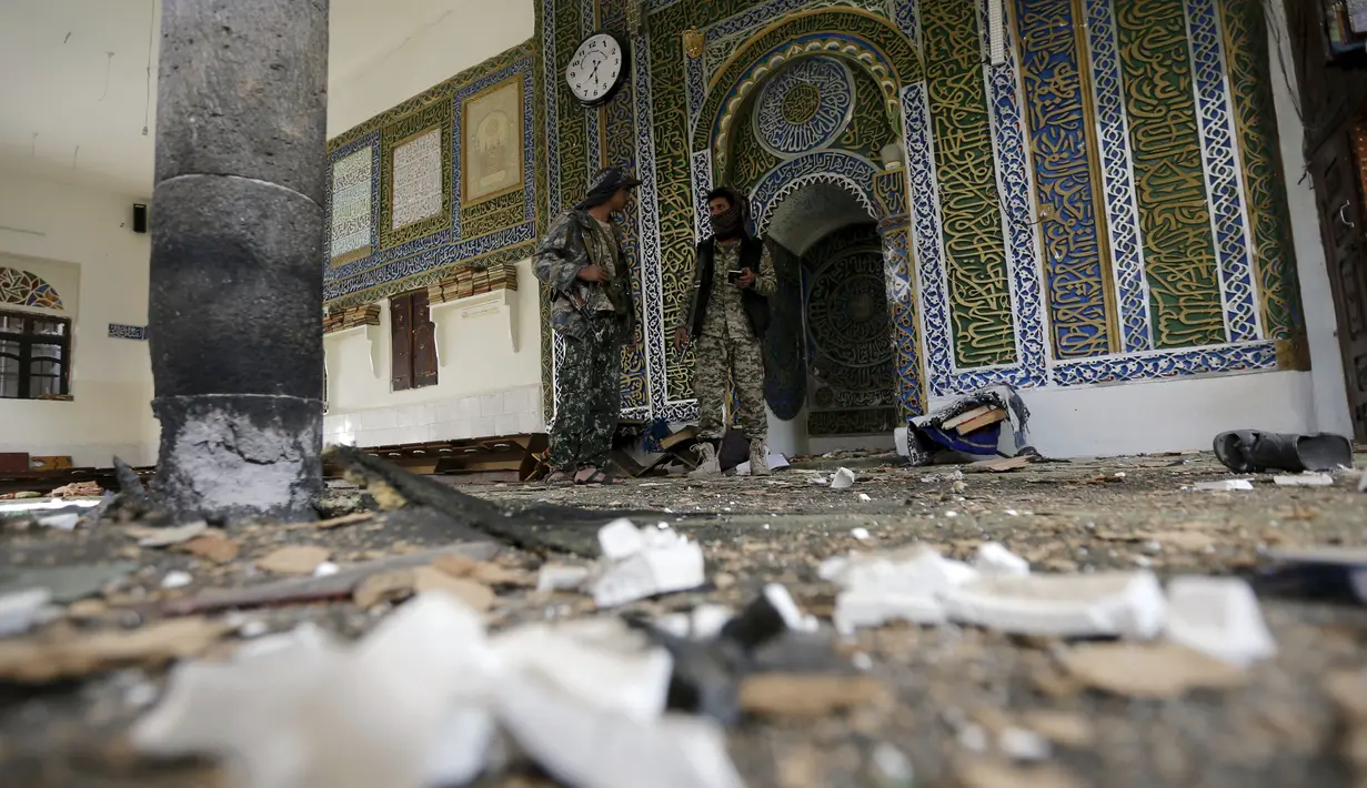 Militan Houthi berdiri di dalam Masjid al-Balili, Yaman pasca pemboman, Kamis (24/9/2015). Ledakan terjadi dua hari setelah Presiden Yaman, Abdrabbuh Mansour Hadi, kembali setelah diasingkan ke Arab Saudi. (REUTERS/Khaled Abdullah)