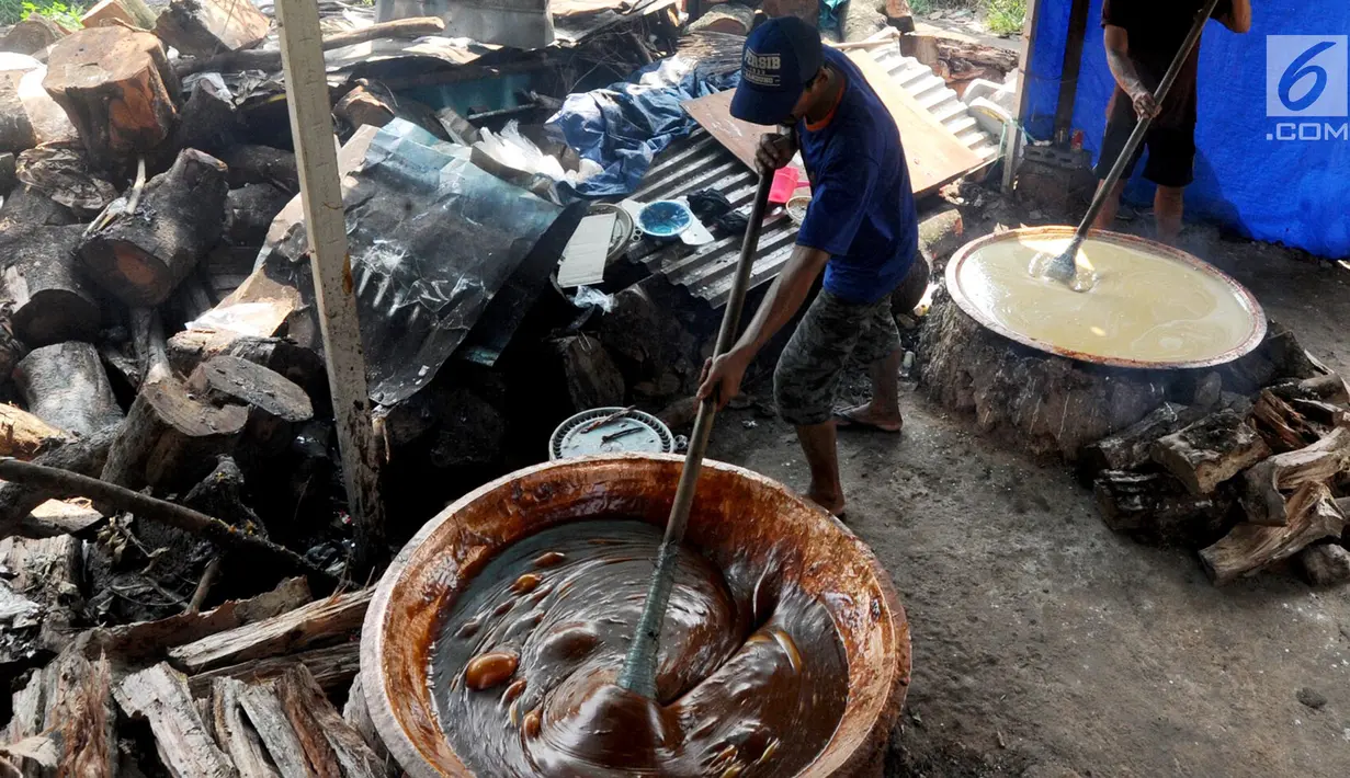 Pekerja mengaduk adonan untuk membuat dodol Betawi di kawasan Studio Alam TVRI, Cilodong, Depok (31/5). Proses pencampuran antara gula dengan beras ini membutuhkan waktu hingga sekitar tujuh jam. (Merdeka.com/Arie Basuki)