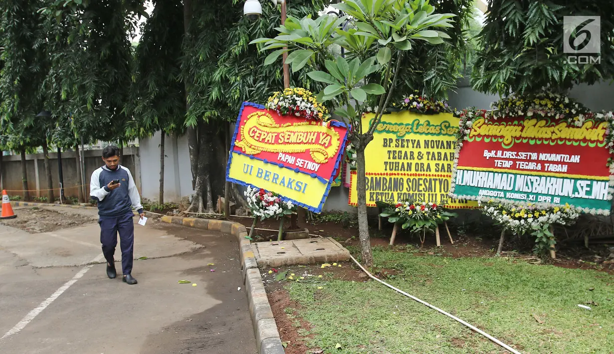 Seorang pria melintas dekat karangan bunga untuk Ketua DPR, Setya Novanto di RSCM Kencana, Jakarta, Minggu (19/11). Pada Jumat (17/11/2017), Setya Novanto dipindahkan ke RSCM untuk mendapat perawatan lebih intensif. (Liputan6.com/Herman Zakharia)