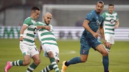 Penyerang AC Milan, Zlatan Ibrahimovic, berebut bola dengan bek Shamrock Rovers, Joey O'Brien, pada laga babak kualifikasi Luga Europa 2020/2021 di Tallaght Stadium, Jumat (18/9/2020) dini hari WIB. AC Milan menang 2-0 atas Shamrock Rovers. (Spada/LaPresse via AP)