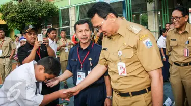 Gubernur DKI Jakarta Basuki Tjahaja Purnama atau Ahok menyalami seorang siswa saat menyambangi SMPN 41 Jakarta, Senin (9/5). Kedatangan Gubernur yang disapa Ahok itu guna meninjau pelaksanaan Ujian Nasional di sekolah tersebut. (Liputan6.com/Yoppy Renato)