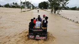 Sejumlah warga menaiki truk untuk melewati jalanan yang tertutup banjir yang disebabkan badai topan Koppu di Nueva Ecija,  Filipina, Senin (19/10/2015). Badai menyebabkan ratusan rumah hancur  dan 10.000 orang terpaksa mengungsi. (REUTERS/Erik De Castro)