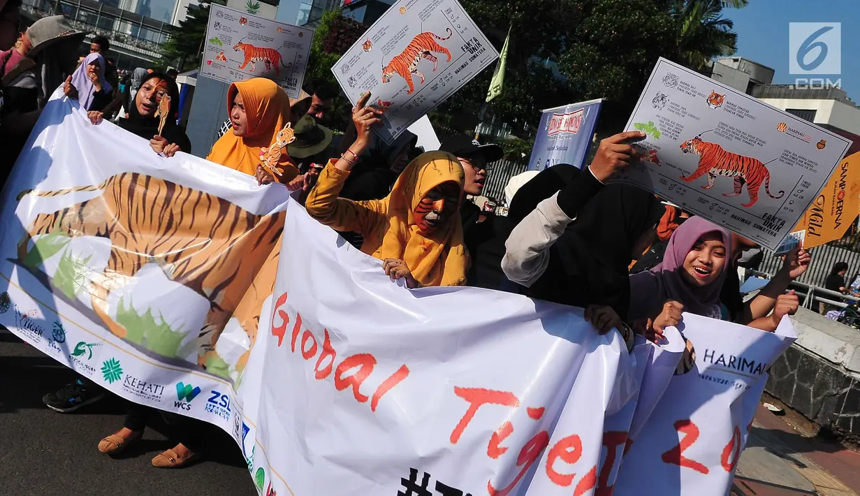 Peserta aksi dari forum harimaukita membentangkan spanduk dan poster saat mengkampanyekan Global Tiger Day di Bundaran HI, Jakarta, Minggu (30/7). Acara ini juga untuk mengimbau dan berusaha menjaga harimau dari kepunahan. (Liputan6.com/Helmi Afandi)