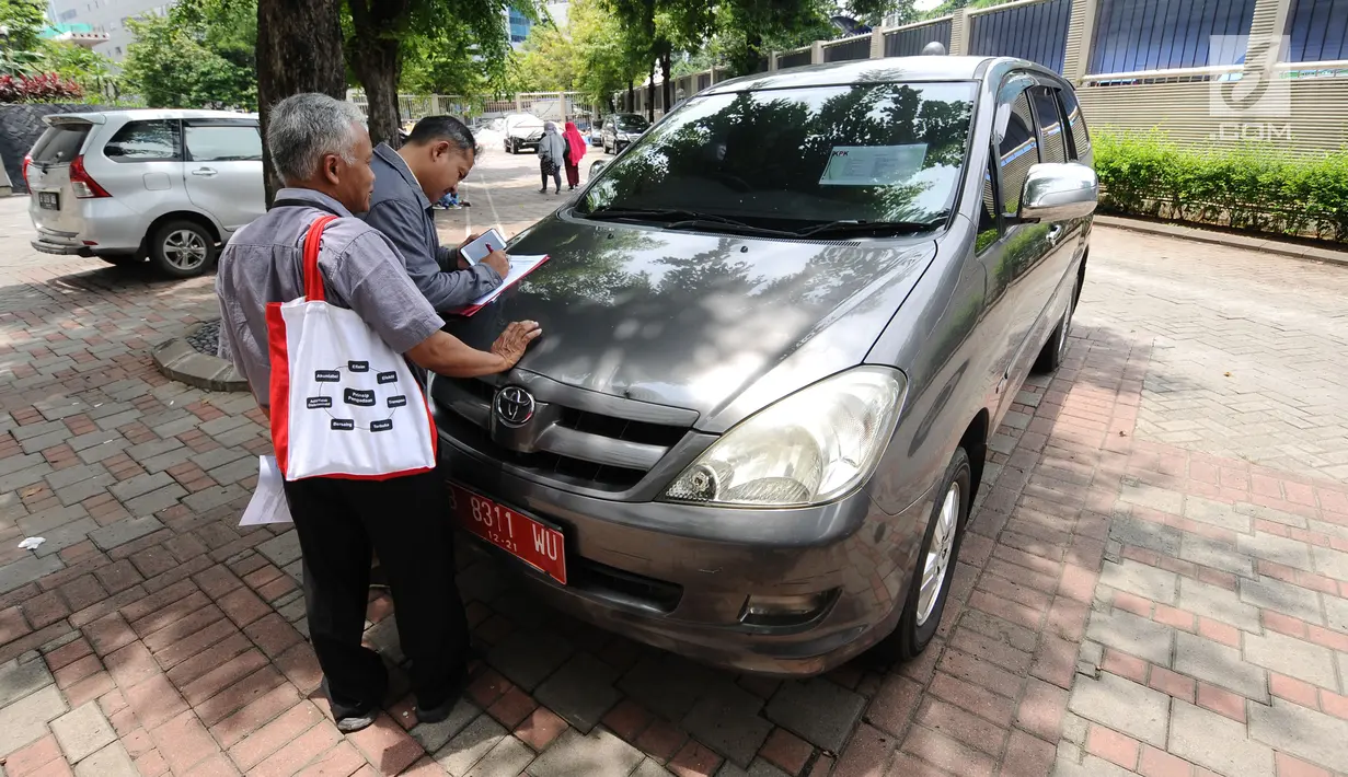 Warga mengecek kondisi mobil operasional KPK yang akan dilelang di Gedung KPK Lama, Jakarta, Selasa (27/2). KPK akan melelang kendaraan operasional inventaris yang telah berumur di atas 10 tahun. (Liputan6.com/Helmi Fithriansyah)