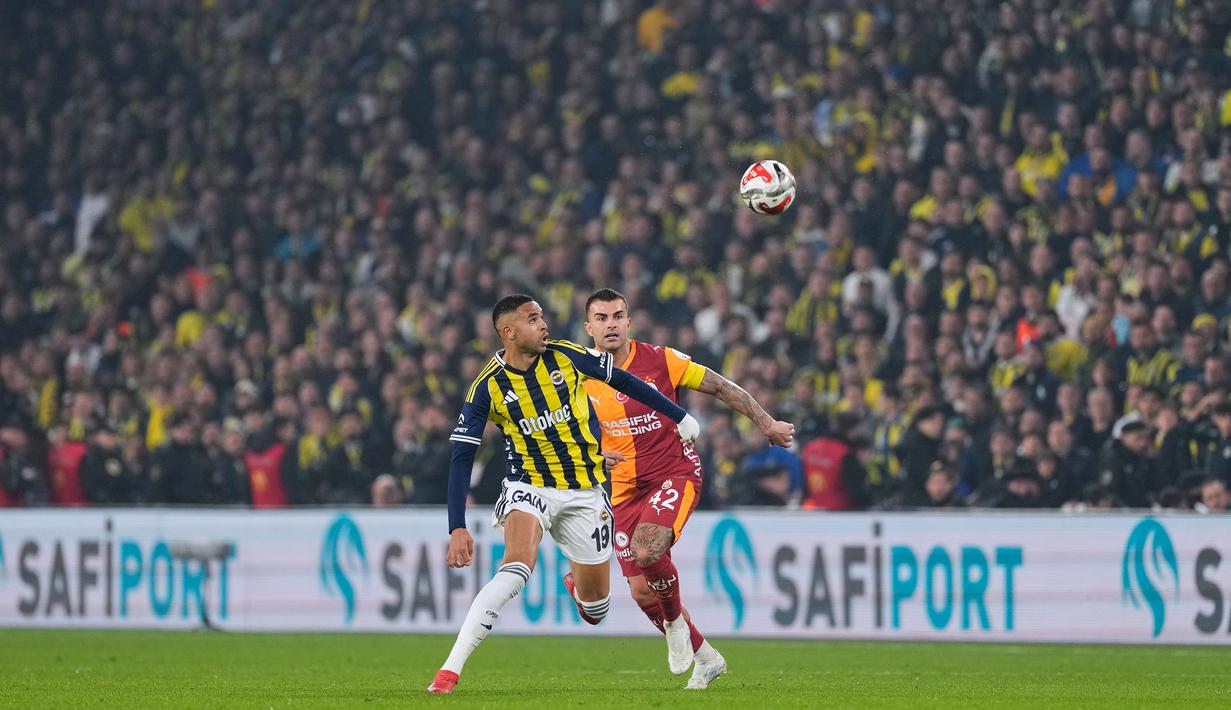 Pemain Fenerbahce, Youssef En-Nesyri (kiri) berebut bola dengan pemain Galatasaray, Abdulkerim Bardakci dalam laga lanjutan Liga Super Turki 2025/2026 antara Fenerbahce melawan Galatasaray di Chobani Stadium, Istanbul, Turki, Senin (01/12/2025) waktu setempat. (AP Photo/Khalil Hamra)