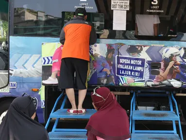 Warga membayar pajak kendaraan bermotor di gerai Samsat Keliling Car Free Day, Jakarta, Minggu (21/10). Agar bisa membayar pajak ini cukup menggunakan STNK dengan nama yang tertera harus sesuai KTP. (Liputan6.com/Angga Yuniar)
