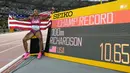 Pelari Amerika Serikat, Sha’Carri Richardson berfoto di samping papan catatan waktu setelah berhasil menorehkan rekor baru pada final 100 meter putri Kejuaraan Dunia Atletik 2023 di National Athletics Centre, Budapest, Hungaria, pada 22 Augustus 2023. (AP Photo/Bernat Armangue)