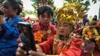 Murid TK Sekolah Alternatif untuk Anak Jalanan (SAAJA) ber-selfie dengan mengenakan pakaian adat di kawasan Kuningan, Jakarta, Selasa (21/4/2015). Kegiatan tersebut dalam rangka Hari Kartini yang diperingati setiap 21 April. (Liputan6.com/Faizal Fanani)