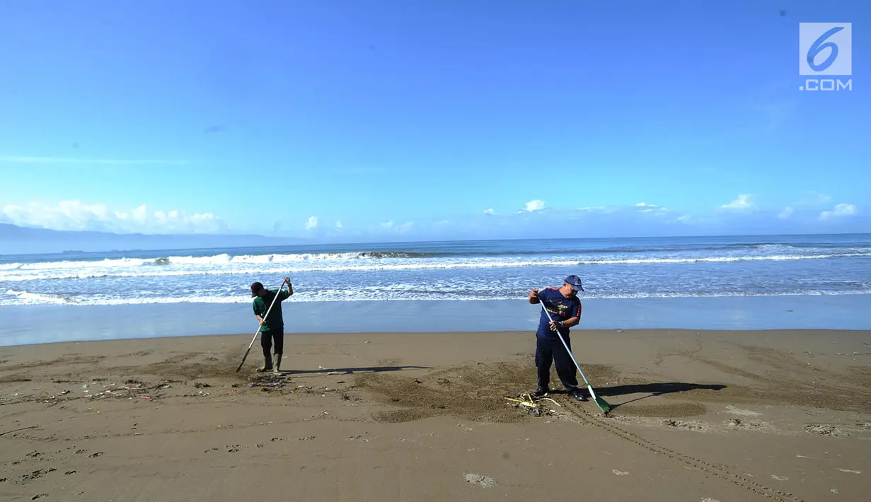 Dua sukarelawan membersihkan sampah di kawasan Pantai Citepus, Pelabuhan Ratu, Sukabumi, Jumat (4/1). Kegiatan aksi Jumsih (Jumat Bersih) setiap minggunya ini sudah berlangsung sejak tahun 2002. (Merdeka.com/Arie Basuki)