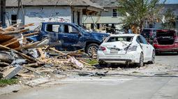 Kendaraan yang rusak diparkir di antara puing-puing dan rumah yang rusak setelah tornado Selasa malam di Arabi, La., Rabu (23/3/2022). (Scott Clause/The Daily Advertiser via AP)