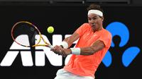Petenis Spanyol, Rafael Nadal mengembalikan bola ke arah petenis Austria, Dominic Thiem dalam pertandingan tenis eksibisi di Adelaide, Jumat (29/1/2021) menjelang berlangsungnya Turnamen Tenis Australia Open. Rafael Nadal menang 7-6, 6-4 atas Dominic Thiem. (AFP/Michael Errey)