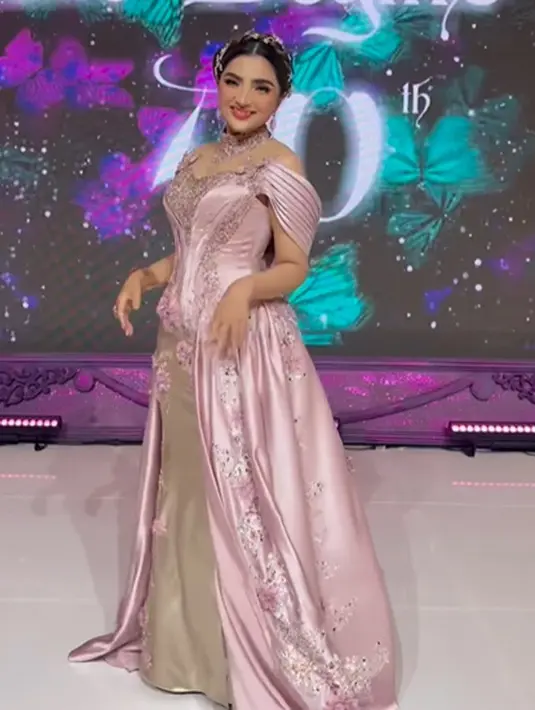 Ashanty sendiri tampil sempurna dibalut dress bernuansa merah muda keunguan yang penuh kilau. Aksen off-the-shoulder dari dressnya dengan train panjang menjuntai hingga ke lantai dipercantik dengan makeup bold dan hair piece yang tak kalah memesona. [Foto: Instagram/ashanty_ash]