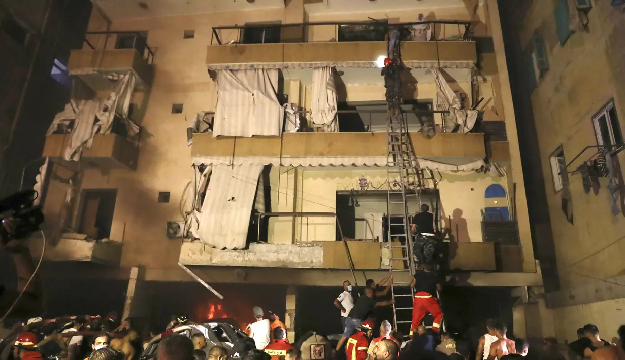 Orang-orang dievakuasi oleh Petugas Pemadam Kebakaran dari apartemen mereka setelah sebuah tangki bensin meledak di lingkungan Tarik al-Jadida, di Beirut, Lebanon (9/10/2020) waktu setempat.  (AP Photo/Bilal Hussein)