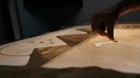 Detail lukisan bergambar Piramida Agung dan Sphinx yang sedang dibuat oleh seniman Mesir, Michael Romany di rumahnya di pinggiran Kairo, Mesir, 25 November 2016. Michael Romany melukis beragam pemandangan menggunakan pasir. (REUTERS/Mohamed Abd El Ghany)