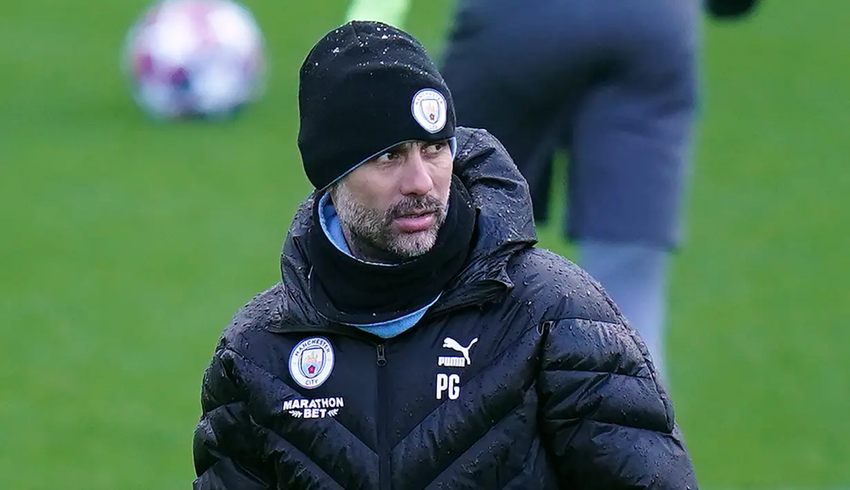 Pelatih Manchester City, Pep Guardiola melihat para pemainnya berlatih di City Football Academy di Manchester, Inggris barat laut (25/2/2020). City akan bertanding melawan Real Madrid pada leg pertama babak 16 Liga Champions di Bernabeu. (AFP Photo/Jon Super)