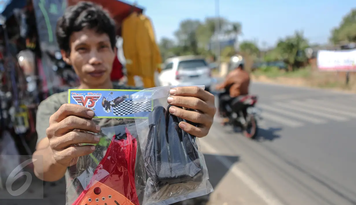 Pedagang menunjukan barang dagangannya di kawasan Kali Malang, Jakarta, Selasa (14/7/2015). Hal ini dikarenakan banyaknya mudik gratis yang diselenggarakan untuk para pengguna motor. (Liputan6.com/Faizal Fanani)