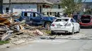 Kendaraan yang rusak diparkir di antara puing-puing dan rumah yang rusak setelah tornado Selasa malam di Arabi, La., Rabu (23/3/2022). (Scott Clause/The Daily Advertiser via AP)
