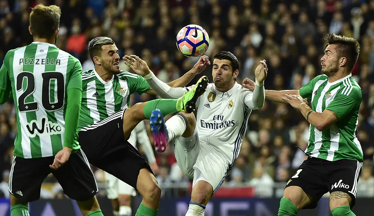 Striker Real Madrid, Alvaro Morata, berebut bola dengan penyerang Real Betis, Dani Ceballos. Pada laga ini Los Blancos turun dengan formasi 4-4-2, sementara Real Betis memakai 5-3-2. (AFP/Gerard Julien)