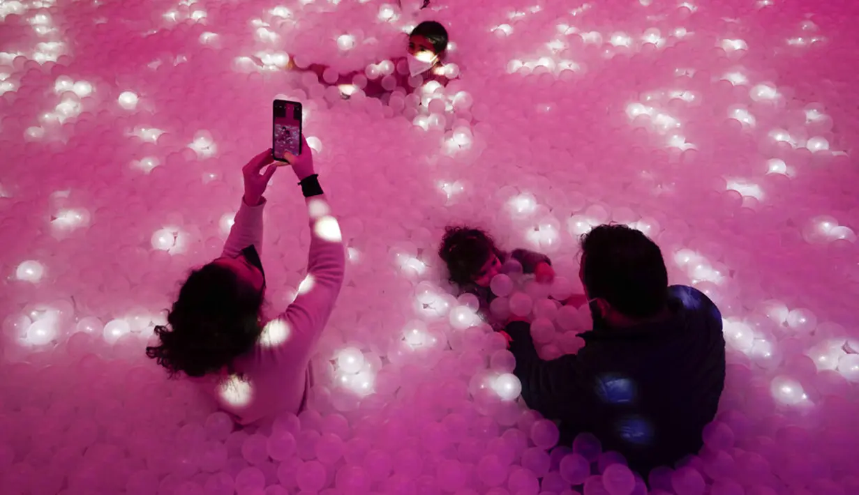 Pengunjung berenang dalam kolam bola pada pameran seni Let's Fly yang seluruhnya terdiri dari balon dan karya seni tiup di Museum Balon Roma, Italia, 5 Januari 2022. (AP Photo/Alessandra Tarantino)