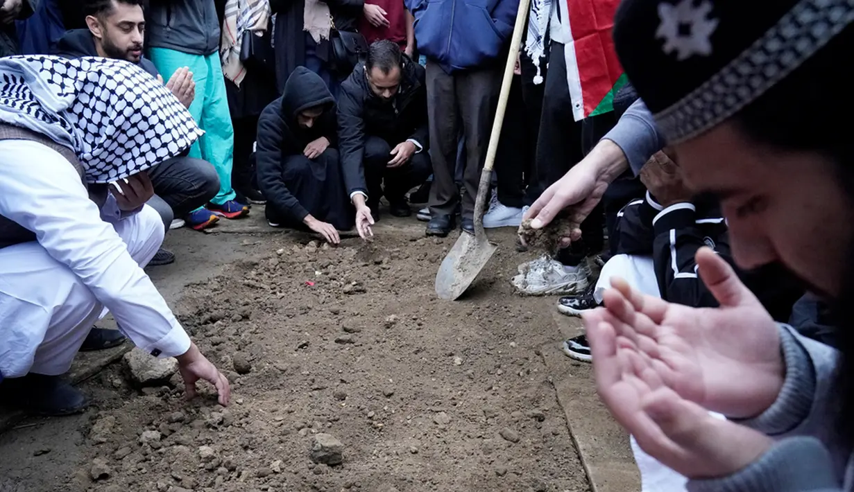 Anggota komunitas muslim berduka atas Wadea Al Fayoume di makamnya di LaGrange, Illinois, Amerika Serikat, Senin (16/10/2023). Seorang pria Illinois didakwa melakukan kejahatan kebencian atau hate crime karena menikam seorang anak laki-laki muslim berusia 6 tahun hingga tewas dan melukai ibunya secara serius. (AP Photo/Nam Y. Huh)