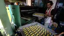 Pengrajin memasukan kue kering Lebaran ke dalam oven, di Kawasan Kwitang, Jakarta, Senin (29/6). Meskipun Lebaran masih beberapa pekan kedepan, produksi kue kering di sentra tersebut meningkat dua kali lipat. (Liputan6.com/Faizal Fanani)