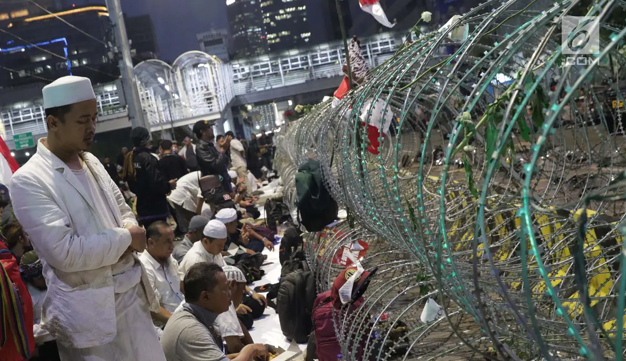 Peserta aksi massa Gerakan Nasional Kedaulatan Rakyat melakukan salat maghrib saat unjuk rasa di depan Gedung Bawaslu, Jalan MH Thamrin, Jakarta, Selasa (21/5/2019). Dalam aksinya, mereka Bawaslu memeriksa hasil Pemilu 2019 yang dinilai banyak terdapat kecurangan. (Liputan6.com/Helmi Fithriansyah)