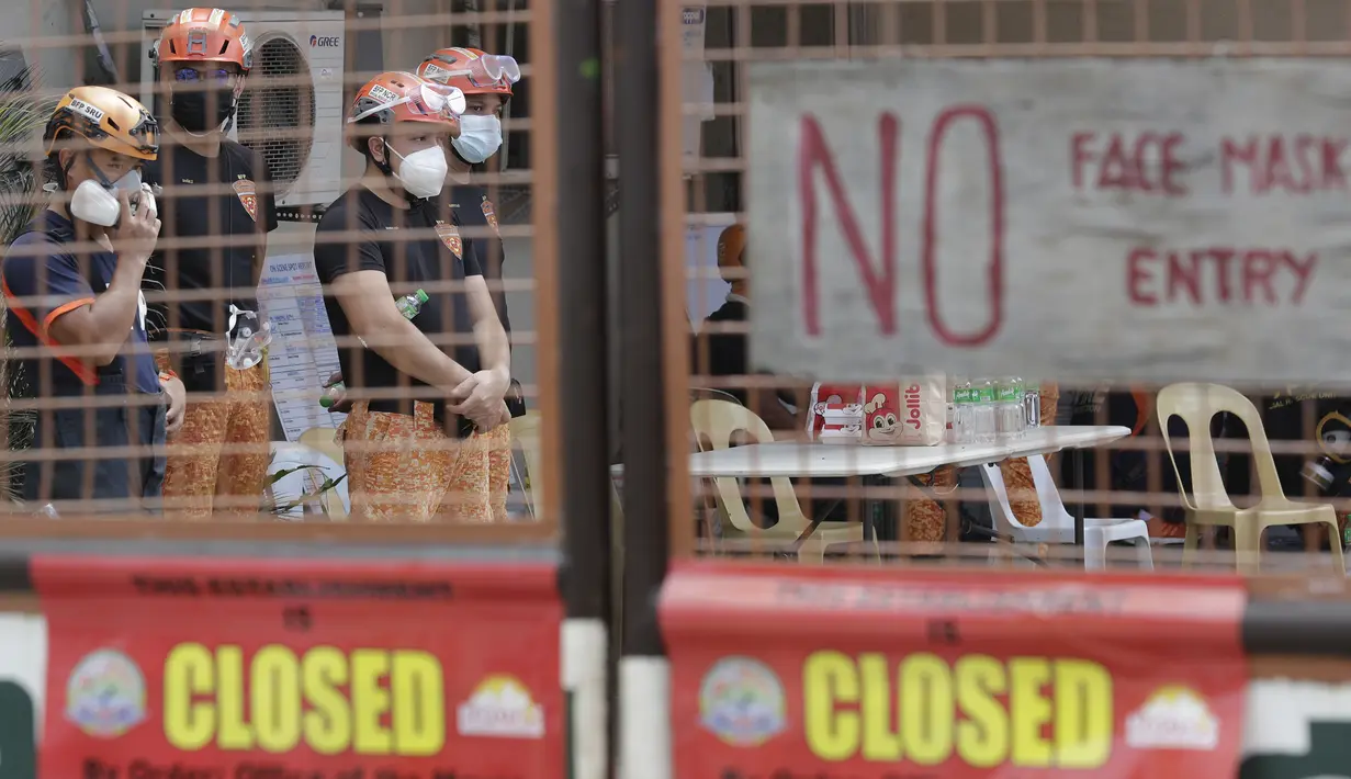 Tim penyelamat berdiri di dalam kompleks Pabrik Es TP Marcelo di Navotas, Filipina, Kamis (4/2/2021). Gas ini bisa menjadi racun bagi manusia jika dihirup dalam jumlah besar, kata seorang pejabat.  (AP Photo/ Aaron Favila)