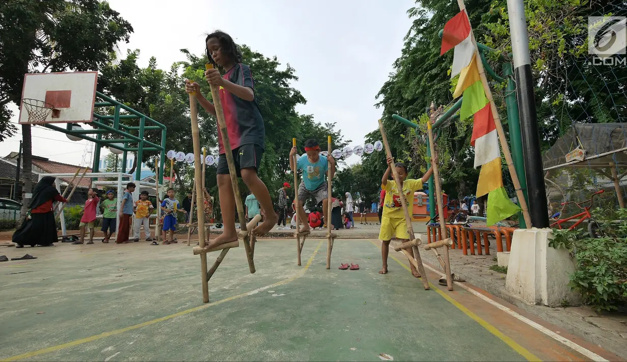 Anak-anak bermain permainan tradisional egrang di RPTRA Melati Duri Pulo, Jakarta, Sabtu (13/10). Traditional Games Returns (TGR) mengampanyekan permainan tradisional dengan mengusung tema "Millenials". (Liputan6.com/Herman Zakharia)