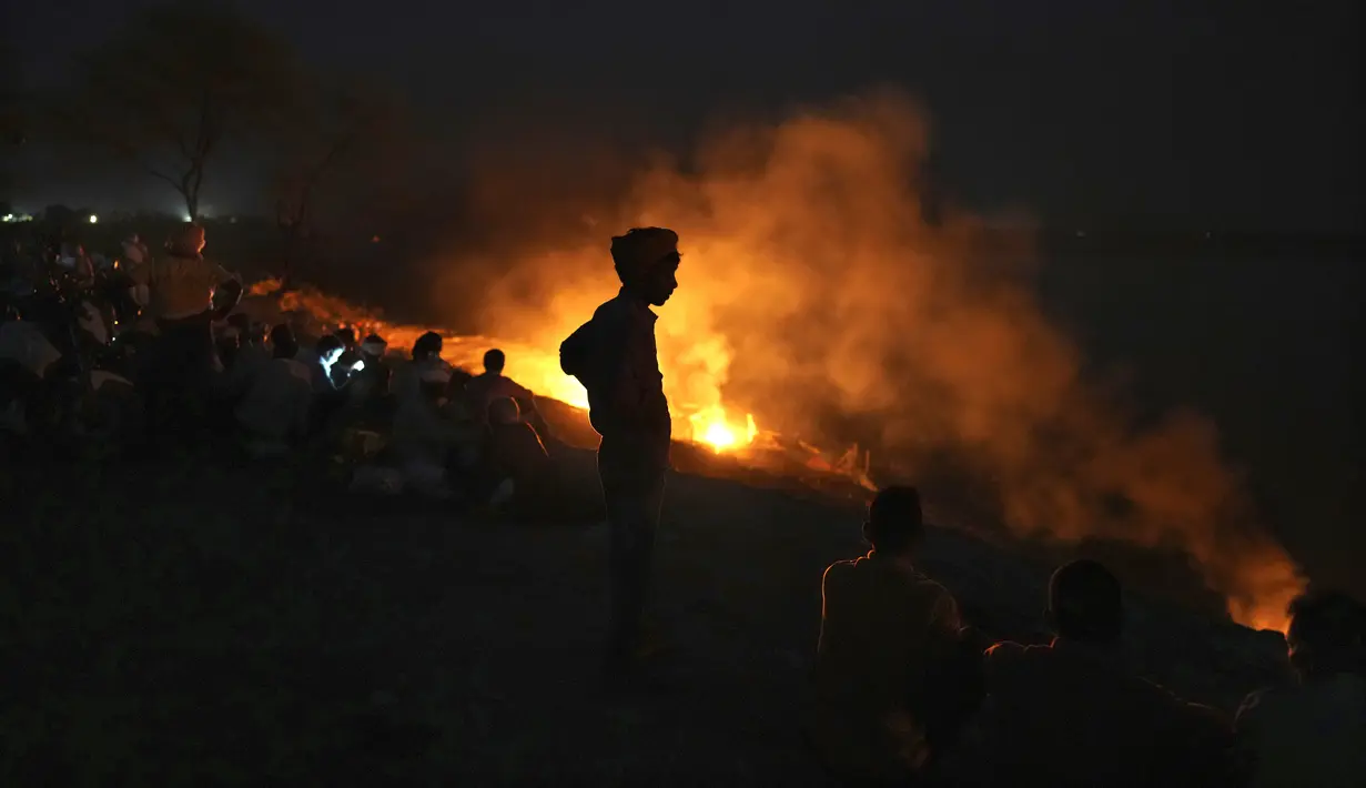 Orang-orang mengkremasi kerabat mereka yang meninggal karena penyakit terkait panas, di Ballia, di negara bagian Uttar Pradesh, India utara, Senin, 19 Juni 2023. (AP Photo/Rajesh Kumar Singh)