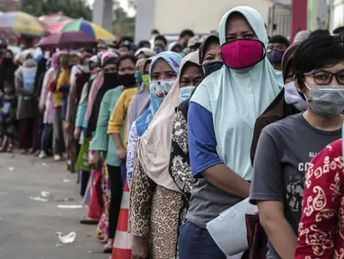 Warga antre untuk menerima Bantuan Sosial Tunai (BST) di Desa Cikande, Kecamatan Jayanti, Kabupaten Tangerang, Banten, Selasa (23/6/2020). Bantuan sebesar Rp 600 ribu per keluarga tersebut diharapkan bisa dimanfaatkan untuk membeli kebutuhan mendesak. (Liputan6.com/Johan Tallo)