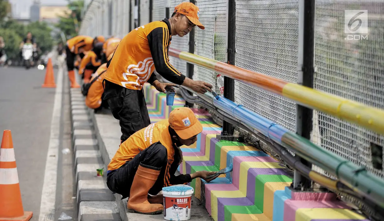 Pasukan oranye atau PPSU melakukan pengecatan jembatan layang dengan warna-warna ceria di Kampung Makasar, Jakarta, Kamis (26/7).  Pengecatan dilakukan guna mempercantik dan menyambut Asian Games 2018 pada Agustus mendatang.  (Liputan6.com/Faizal Fanani)