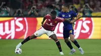 Pemain Manchester United, Kobbie Mainoo (kiri) berebut bola dengan pemain ASEAN All-Stars, Kealey Adamson dalam laga persahabatan yang berlangsung di Stadion Bukit Jalil, Malaysia, pada hari Rabu (28/5/2025) malam waktu setempat. (AP Photo/Vincent Thian)