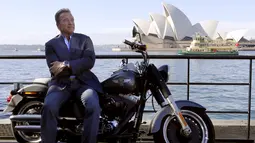Arnold Schwarzenegger berpose di atas motor Harley Davidson di depan Sydney Opera House, Australia, Kamis (4/6/2015). Aktor AS berusia 67 mengunjungi Sydney untuk menghadiri pemutaran perdana film terbaru 'Terminator Genisys'. (REUTERS/David Gray)