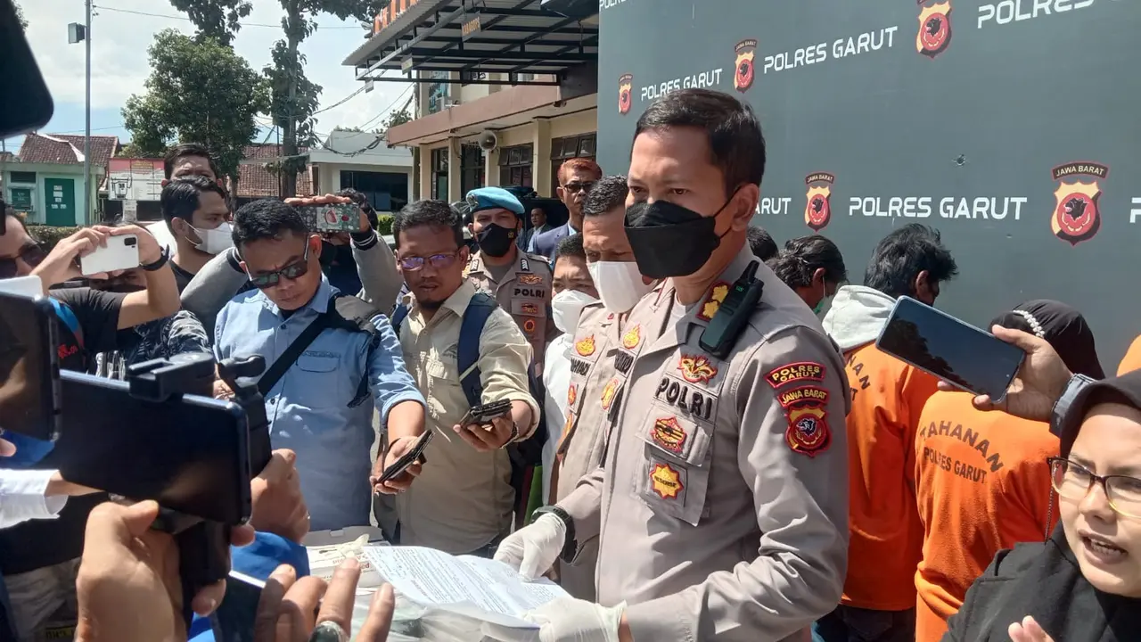 Kapolres Garut, AKBP Wirdhanto Hadicaksono, menunjukan sejumlah barang bukti dalam kasus pengrusakan rumah oleh rentenir saat rilis kasus di Mapolres Garut, Selasa (20/9/2022). (Liputan6.com/Jayadi Supriadin)