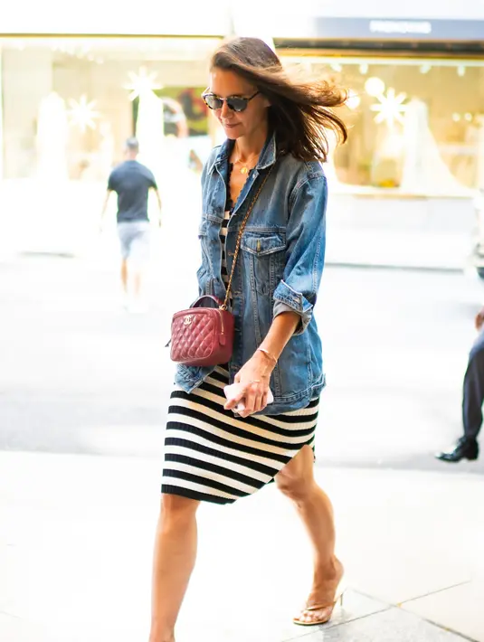 Tas Chanel ini merupakan salah satu favorit Katie Holmes. Kali ini ia memadukannya dengan dress midi bermotif garis dan sepatu dari Gianvito Rossi Calypso. Foto: Vogue.