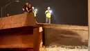 Petugas berwenang menyelidiki runtuhnya jembatan layang di jalur Interstate 85 di Atlanta, AS, Kamis (30/3). Kebakaran hebat yang terjadi di kolong jembatan itu menyebabkan jembatan layang tersebut rapuh dan runtuh. (AP Photo/David Goldman)