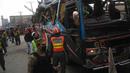 Polisi melakukan penyelidikan di sekitar badan bus usai diserang bom di Peshawar, Pakistan, Rabu (16/3). Bus yang membawa rombongan pegawai pemerintah ini menewaskan setidaknya 10 orang dan 27 lainnya terluka. (AFP / A Majeed)