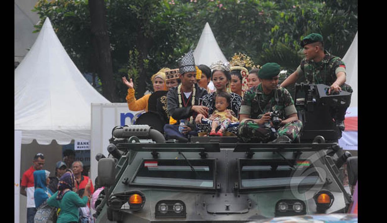 Sejumlah pasangan pengantin yang menaiki panser TNI AD, melakukan prosesi arakan pengantin saat Resepsi Penikahan Massal Pengantin se-Jabodetabek di Istora Senayan, Jakarta, Rabu (28/1/2015). (Liputan6.com/Herman Zakharia)